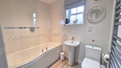 Situated on the upper floor, the master bathroom contains a bath with an overhead shower.